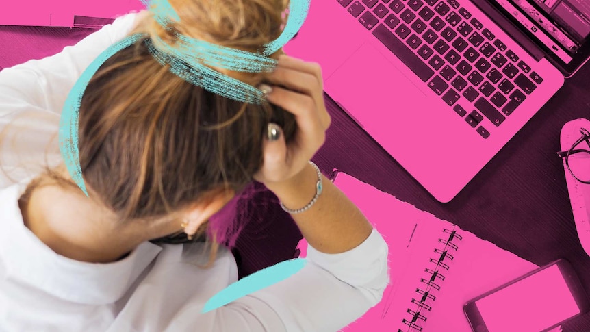 Stressed out woman leans over her computer at work