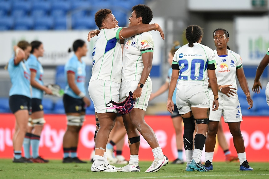 Vika Matarugu and Akosita Ravato of Fiji Drua embrace on field as they celebrate victory. 