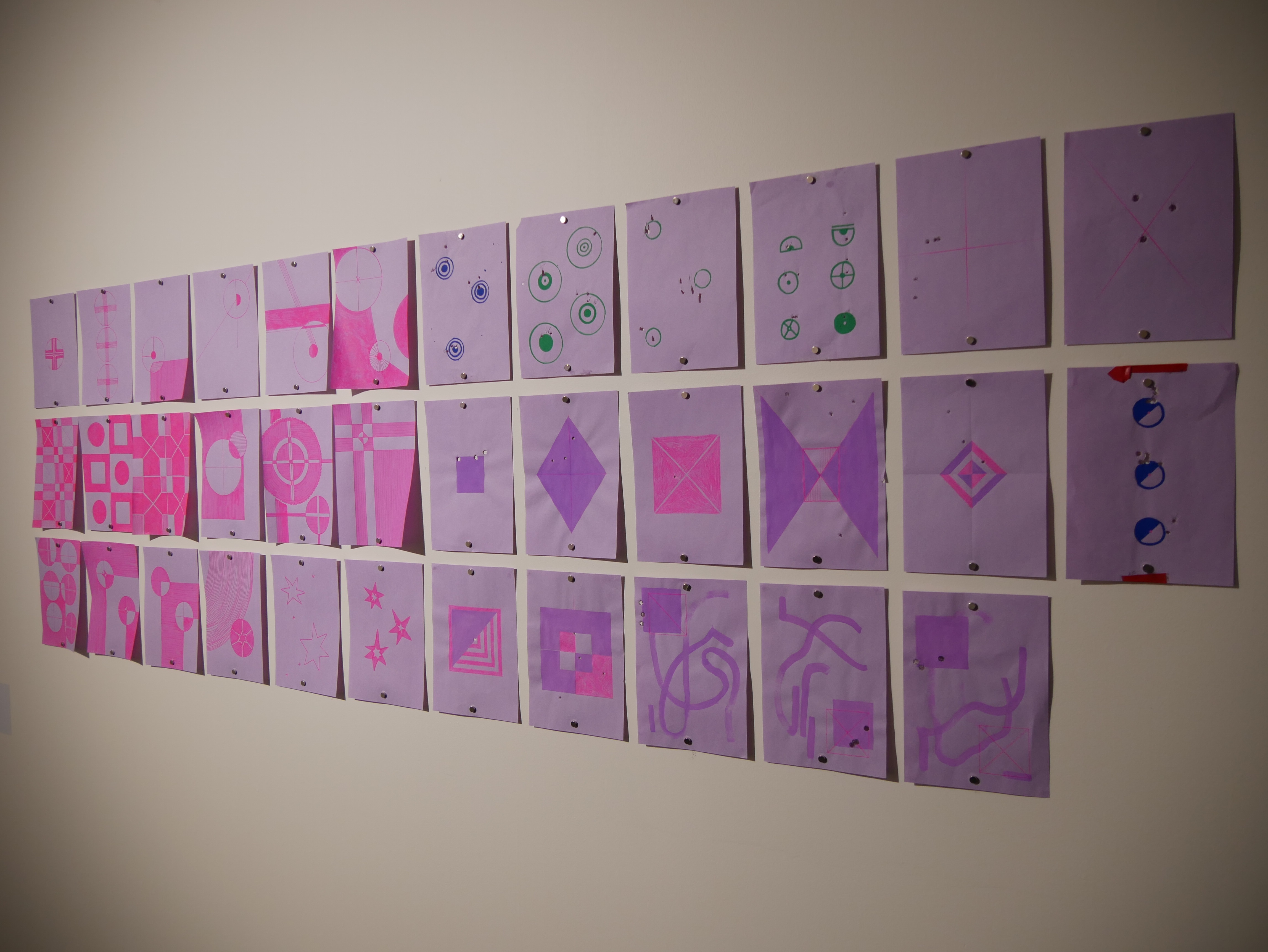 Кусочки фиолетовой бумаги с нарисованными на них узорами.