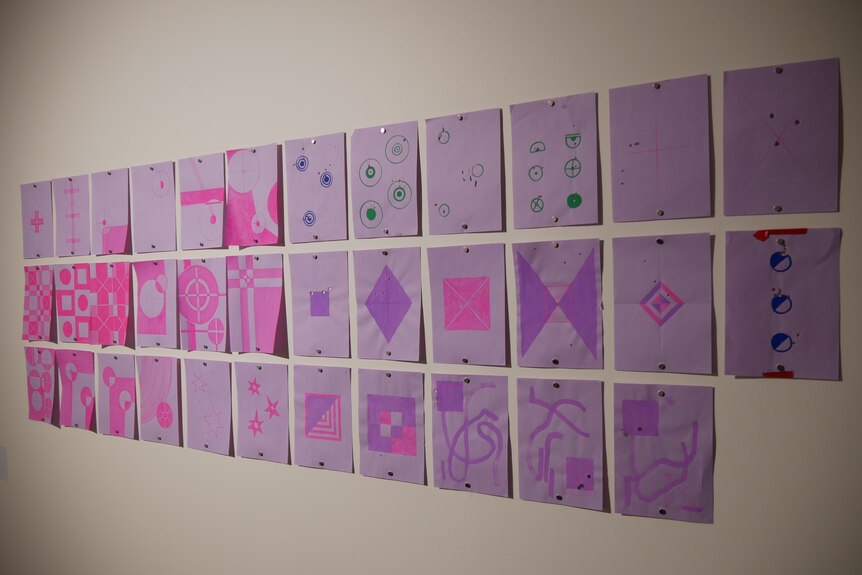 Purple pieces of paper with patterns drawn on them.