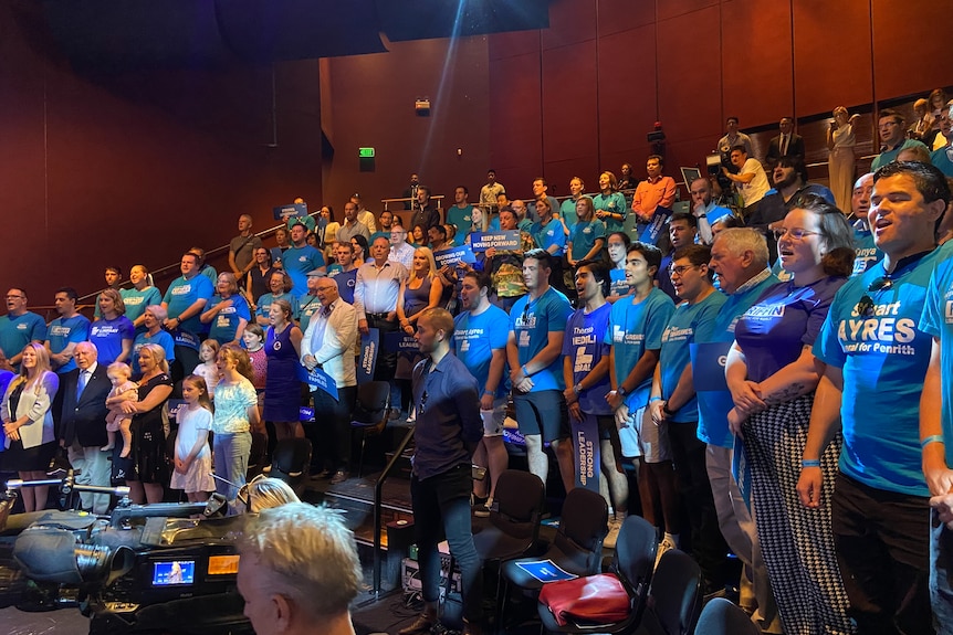 A crowd of people wearing blue t shirts