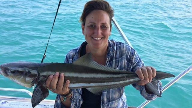 Woman holds up a Cobia fish