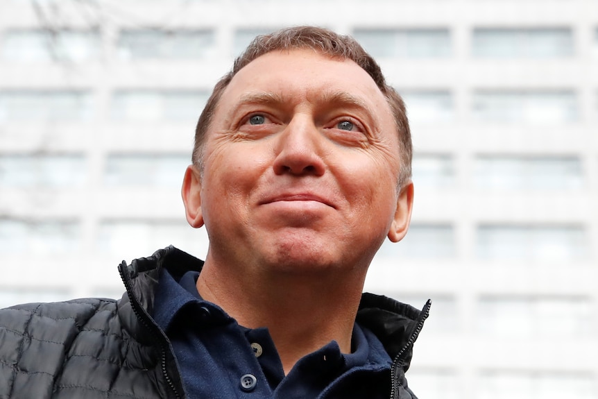 Oleg Deripaska in a black puffer with a slight smile on his face 