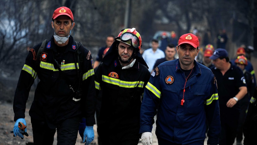 Rescuers arrive at the area where bodies were found following a wildfire at the village of Mati.