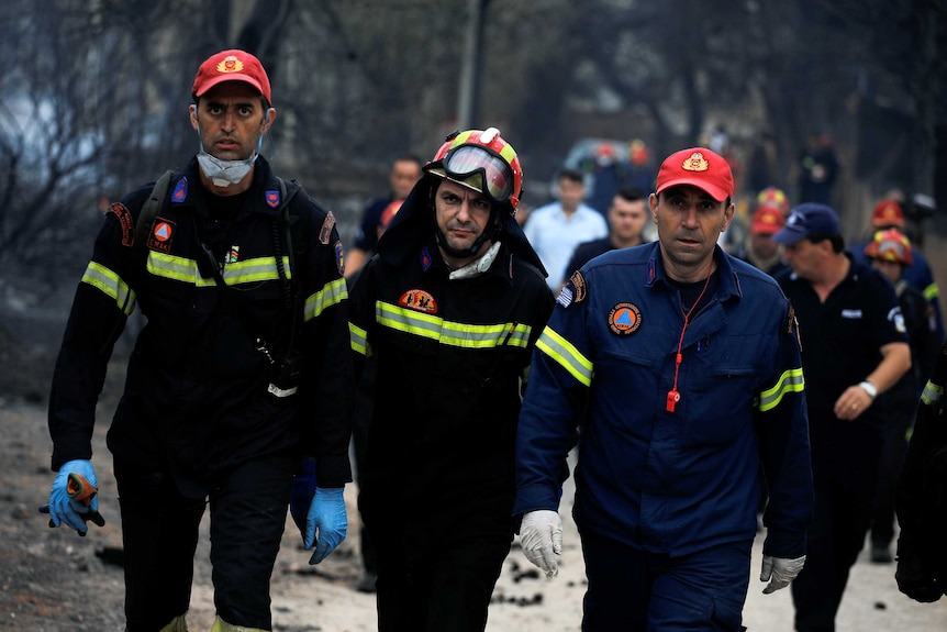 Rescuers arrive at the area where bodies were found following a wildfire at the village of Mati.
