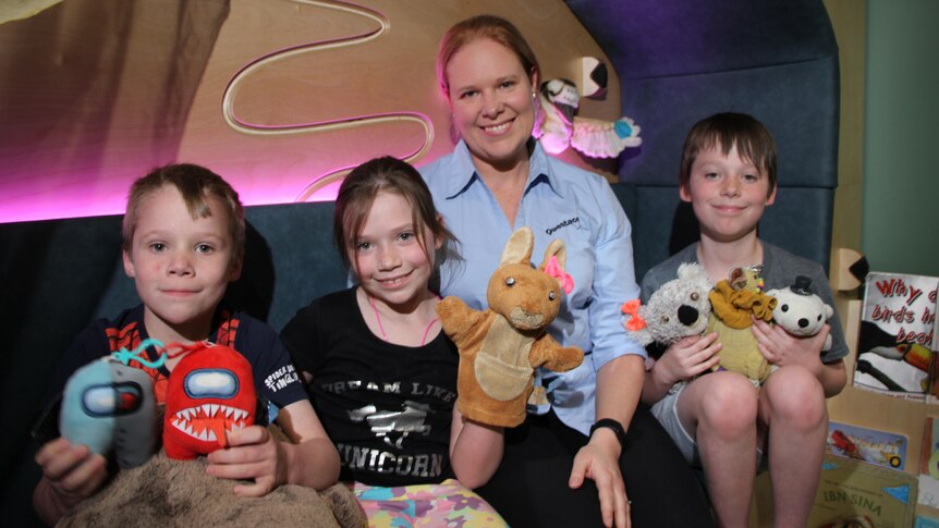 A young family smiling while at Questacon