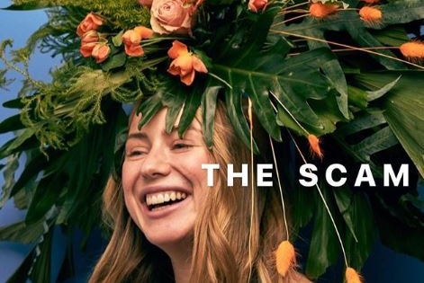 Caroline Calloway laughs as she poses with a head-dress made of plants.