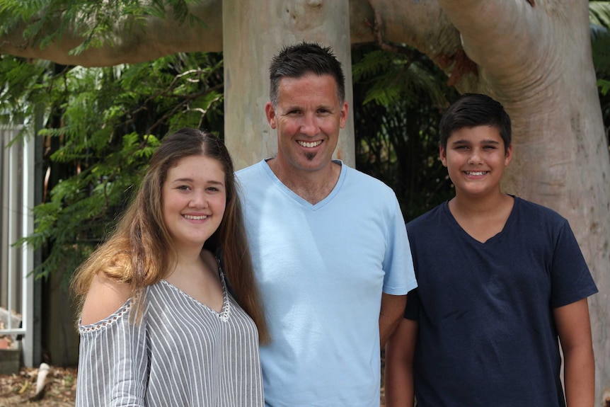 Peter smiles with his children Zoe and Myles