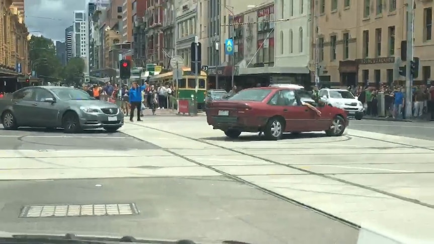 People stopped to film the car as it did doughnuts near Federation Square