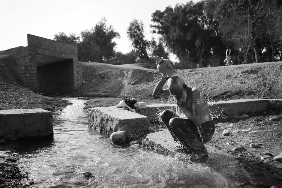 Haji Hazrat, originally from Afghanistan's Nangarhar Province, bathes himself in a canal outside Jalalabad