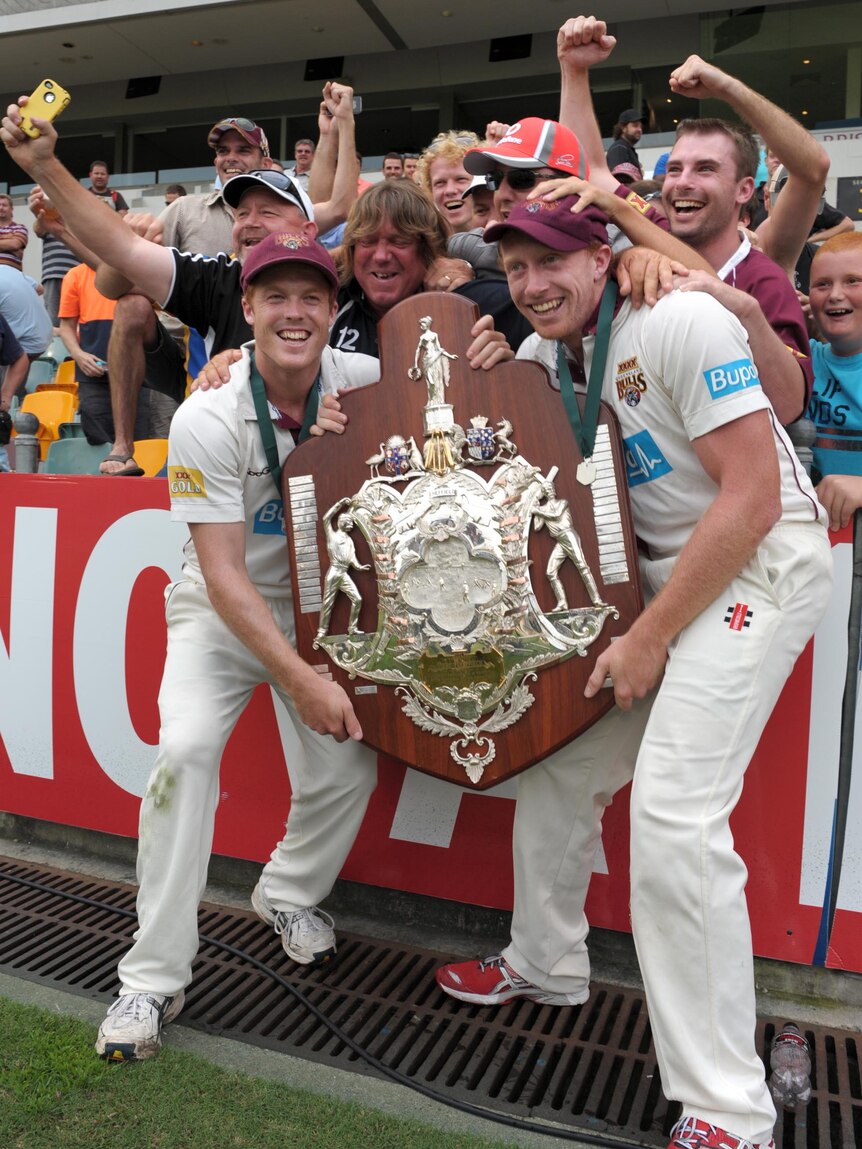 Queensland Bulls players Alister McDermott and Alex Kemp celebrate with supporters.