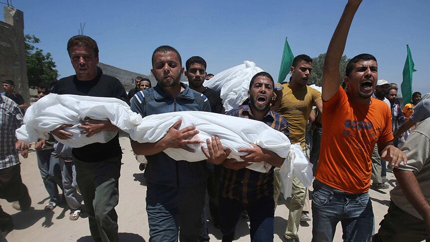 Mourners carry the bodies of Palestinian children, whom medics said were killed in an Israeli air strike.