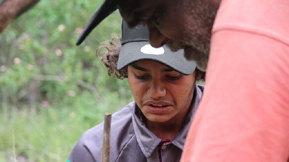 Justin Bonardio learns to make fire with Indigenous elder Russell Butler in bush setting.
