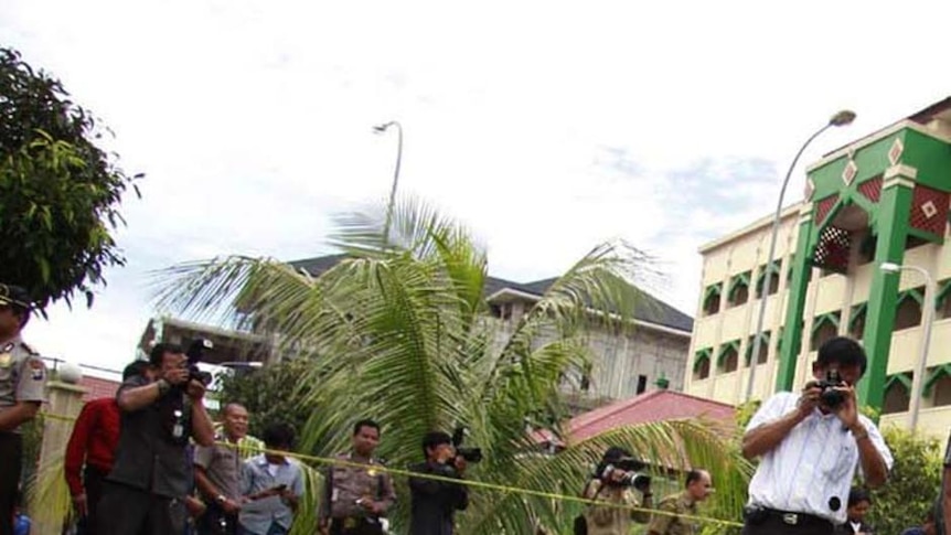 Indonesian police examine fallen debris.
