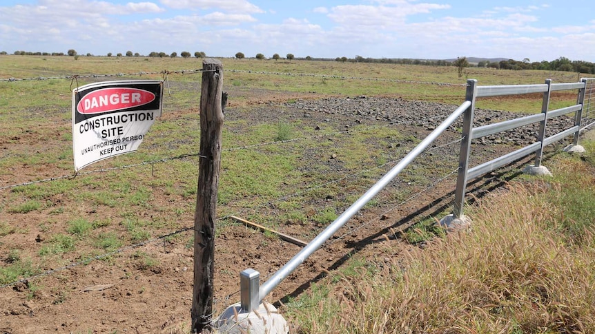 Construction site signage on fence at site of proposed rail corridor for Adani's Carmichael coal mine.