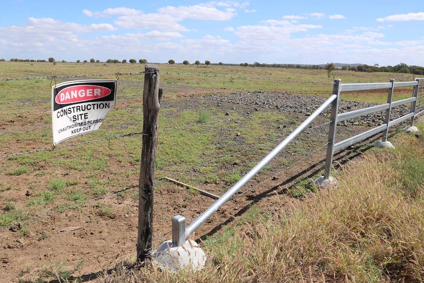 Construction site signage on fence at site of proposed rail corridor for Adani's Carmichael coal mine.