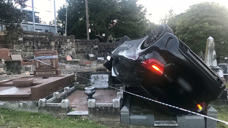 A car sits on top of tombstones at a cemetery in Coogee
