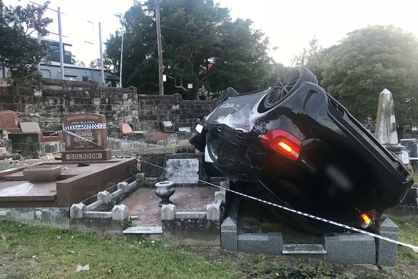 A car sits on top of tombstones at a cemetery in Coogee