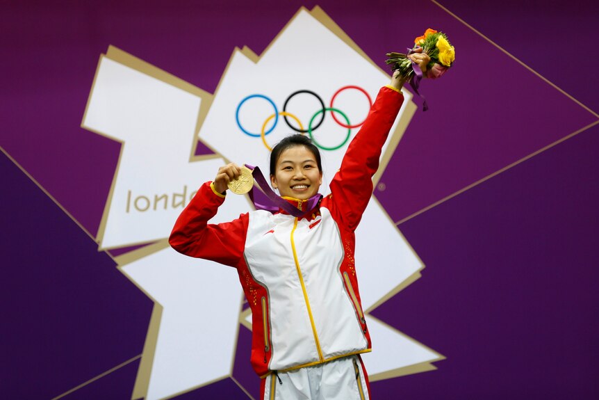 Winners are grinners ... China's Yi Siling holds the first gold medal of the London 2012 Olympics.