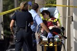 Emergency personnel help a woman who was among those injured in the Orlando shooting spree.