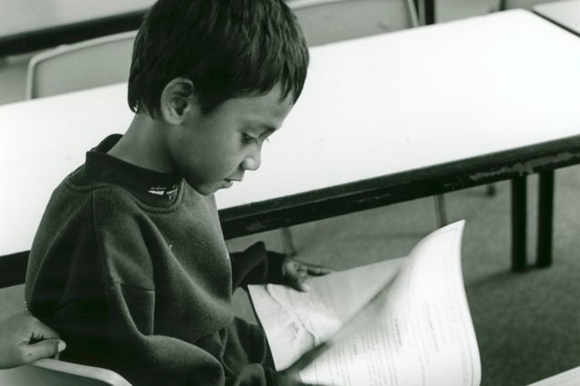 An East Timorese boy looks at a book in a classroom at the Puckapunyal Safe Haven in 1999.