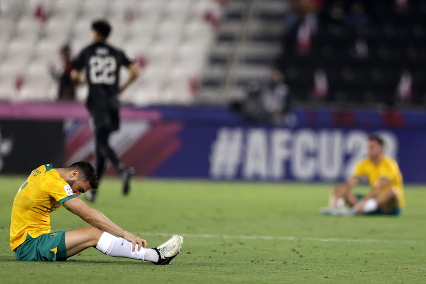 Olyroos players sit on the ground after a 0-0 draw with Qatar at the AFC U23 Asian Cup.