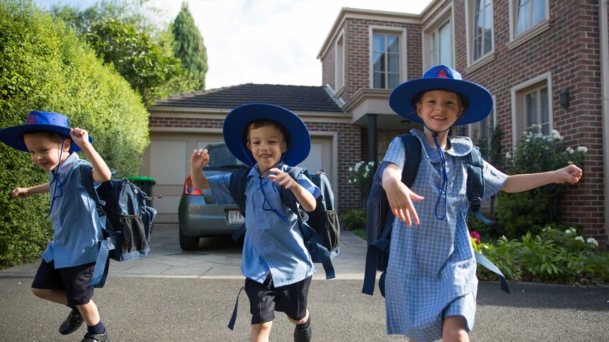 The triplets look excited in their school uniforms.