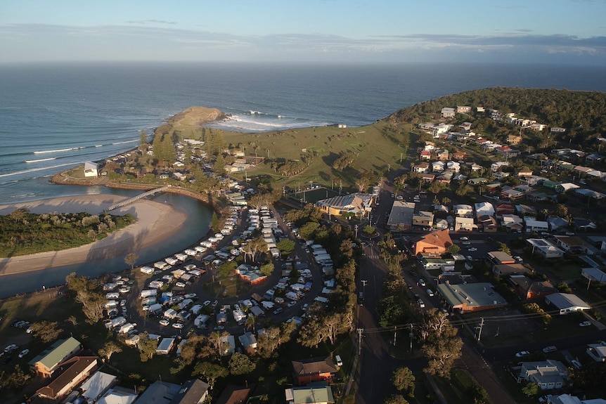 An aerial view of a coastal town, with it's point surf break in the distance.