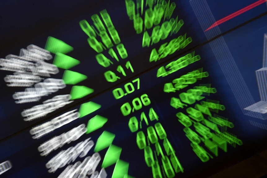 A stock market board shows green