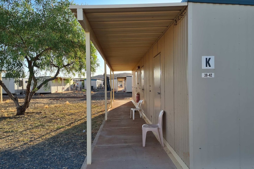 Plastic chairs sit outside the door of metal structures built to house FIFO workers