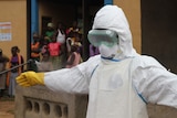 Ebola worker in white suit being sprayed with disinfectant