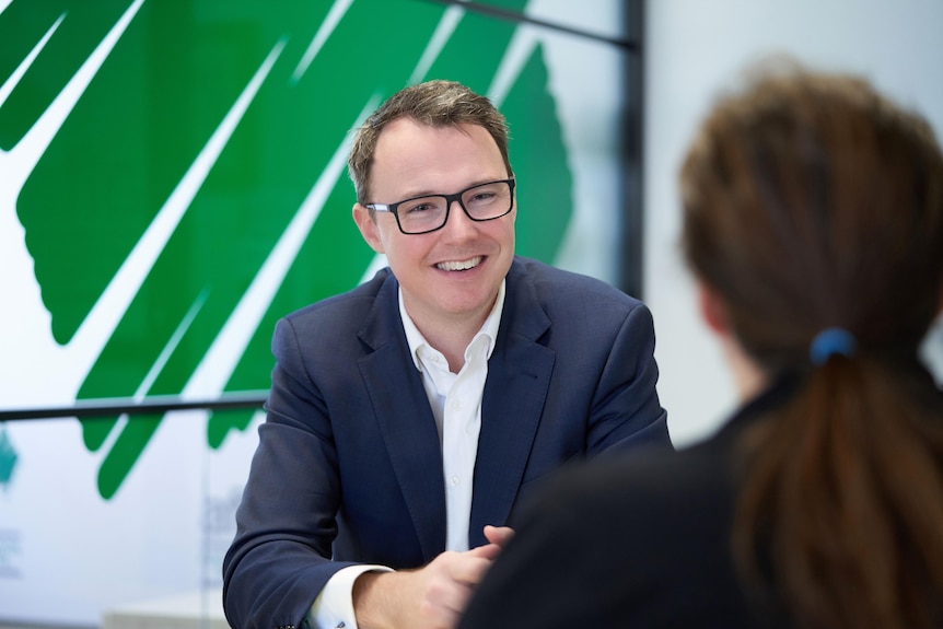 A man wearing frames smiles 