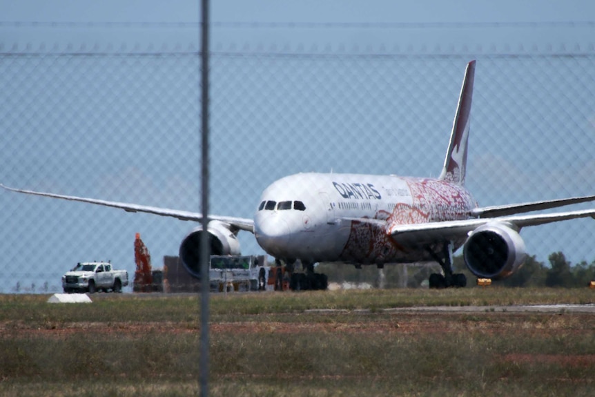 A Qantas plane seen from a distance in a heat haze.