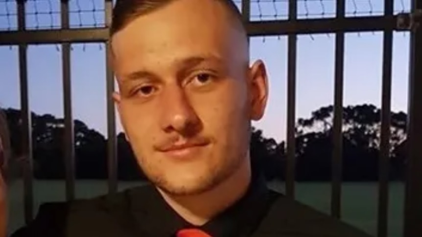 A close-up photo of a young man wearing a collared shirt and tie.