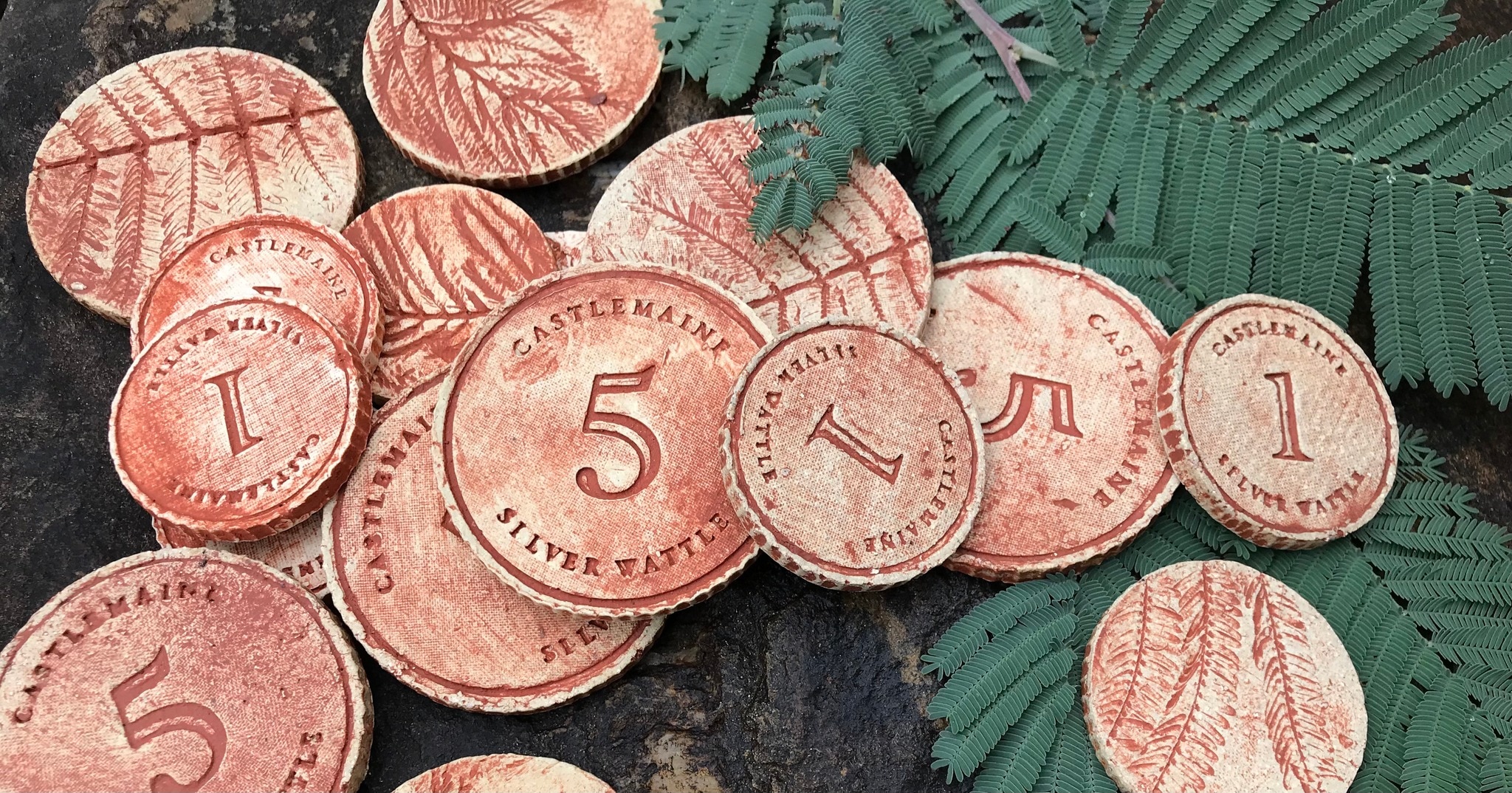 coins made out of clay with 1 and 5's on them, with a wattle print on the back.