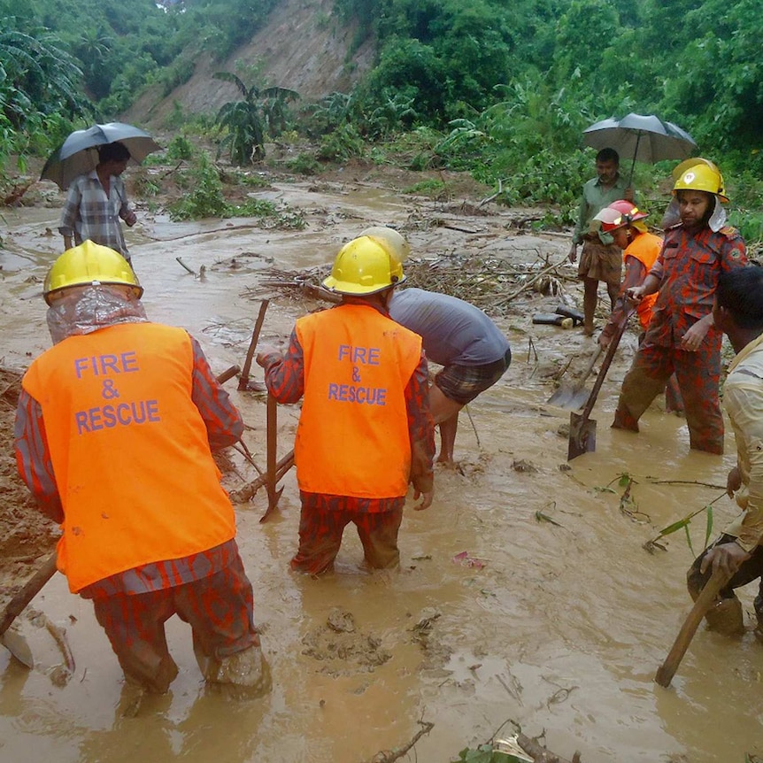Rescuers search through mud after a landslide.