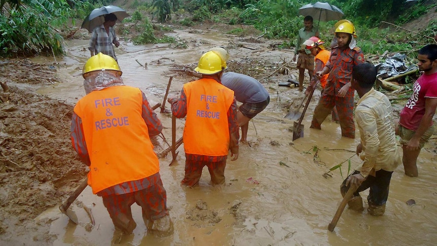 Rescuers search through mud after a landslide.