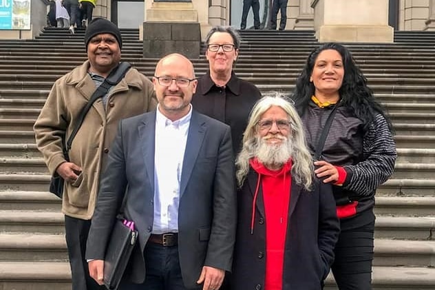 Five people stand on the steps of Victoria's Parliament