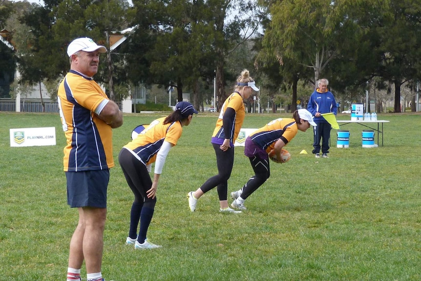 Wally Lewis (L) and Jamie-Lee Lewis (second from L) at kick-off at the silent touch football game held in Canberra as part of 2014 Hearing Awareness Week.