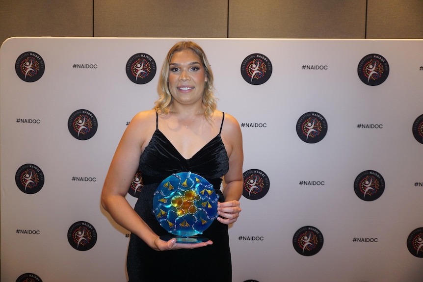 Professional netballer Donnell Wallam holding an award. 