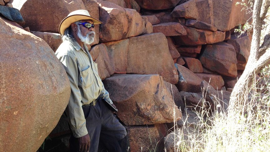 Indigenous ranger Geoffrey Togo stands near the graffiti at Burrup