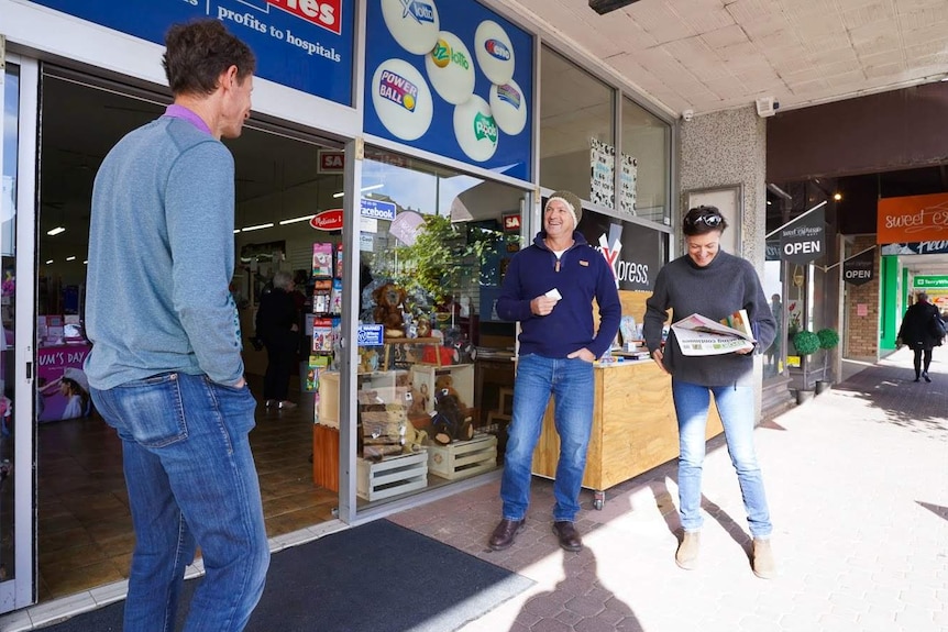 Michael Waite stands and chats with a couple in their 40s outside Naracoorte's newsagent.