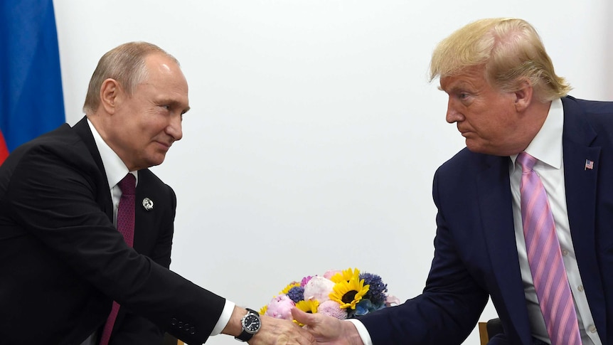 President Donald Trump, right, shakes hands with Russian President Vladimir Putin.