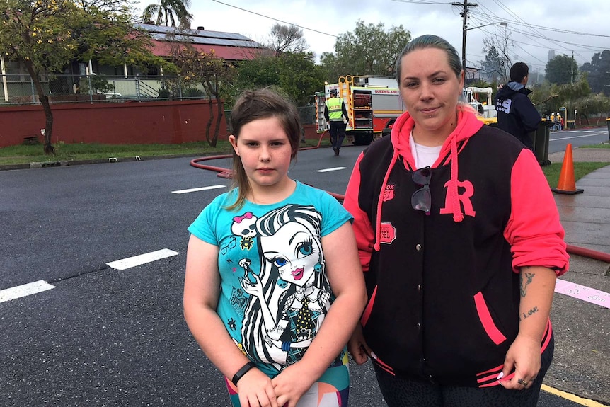 Keenan Turner and Sophie Turner standing outside Morningside State School where fire has destroyed a number of buildings.