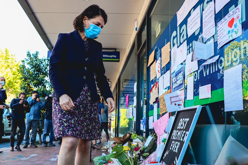 Gladys Berejiklian looks at tributes outside her office