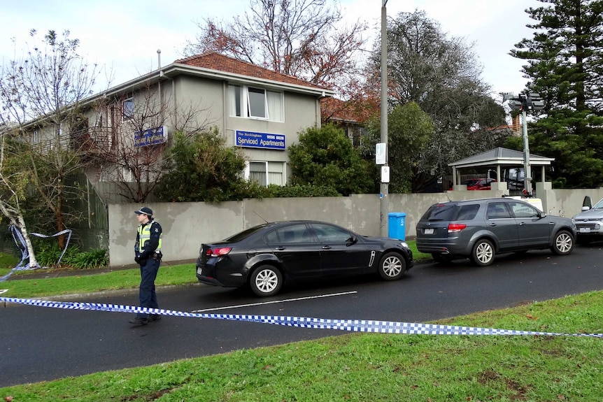 A police woman stands near crime scene tape outside The Buckingham serviced apartments in Brighton