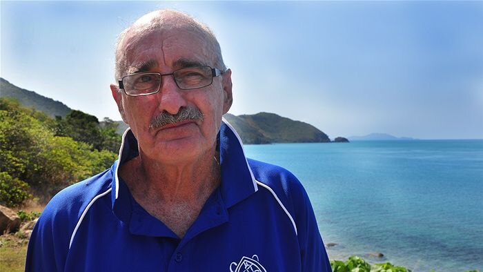 Jon Brodie standing on the shore with the north Queensland coast stretching out behind him