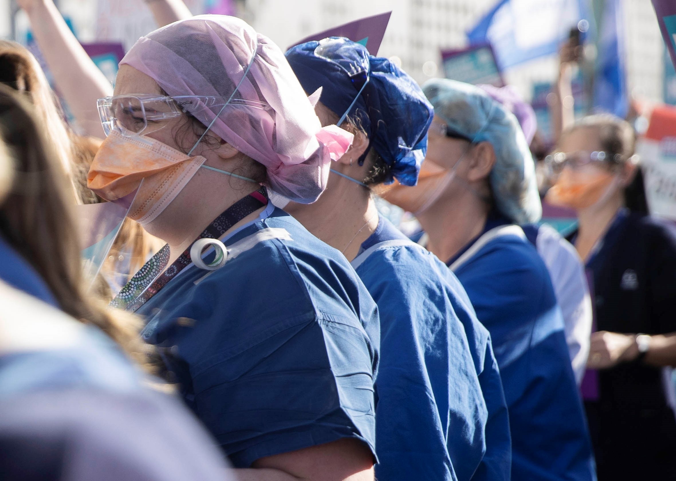 Un grupo de enfermeras miran en la misma dirección.