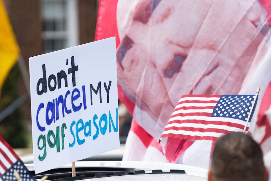 A protest sign reading "Don't Cancel My Golf Season"