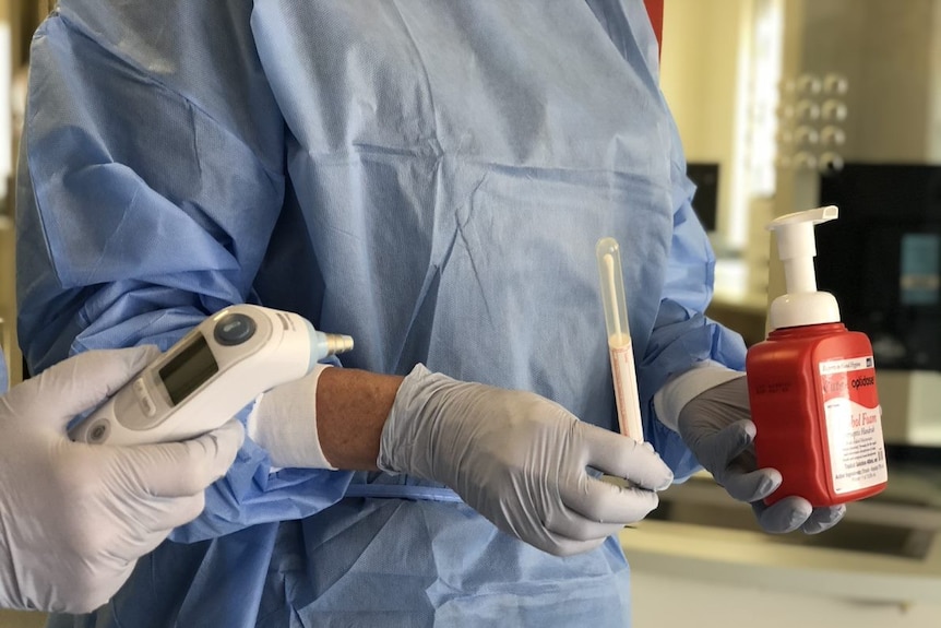 Bunbury doctors holding testing equipment and sanitiser.